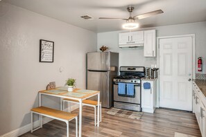 A compact kitchen with a refrigerator, stove, and ceiling fan. - Bakersfield Home w/ Workspace, Near Hospitals (Bakersfield)