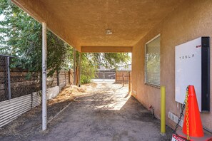 An outdoor covered area with a dirt path leading to a building with a whiteboard. - Bakersfield Home w/ Workspace, Near Hospitals (Bakersfield)
