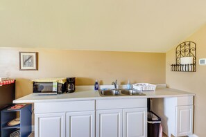 A kitchen with a microwave, coffee maker, sink, and a small trash bin. - Couple’s Retreat 4 Mi to Dtwn! Gateway to Glacier (Columbia Falls)