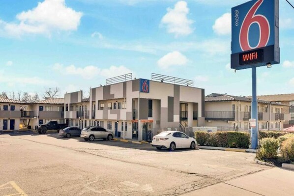 A motel with a '6' sign, a parking lot, and a 'WiFi' sign.