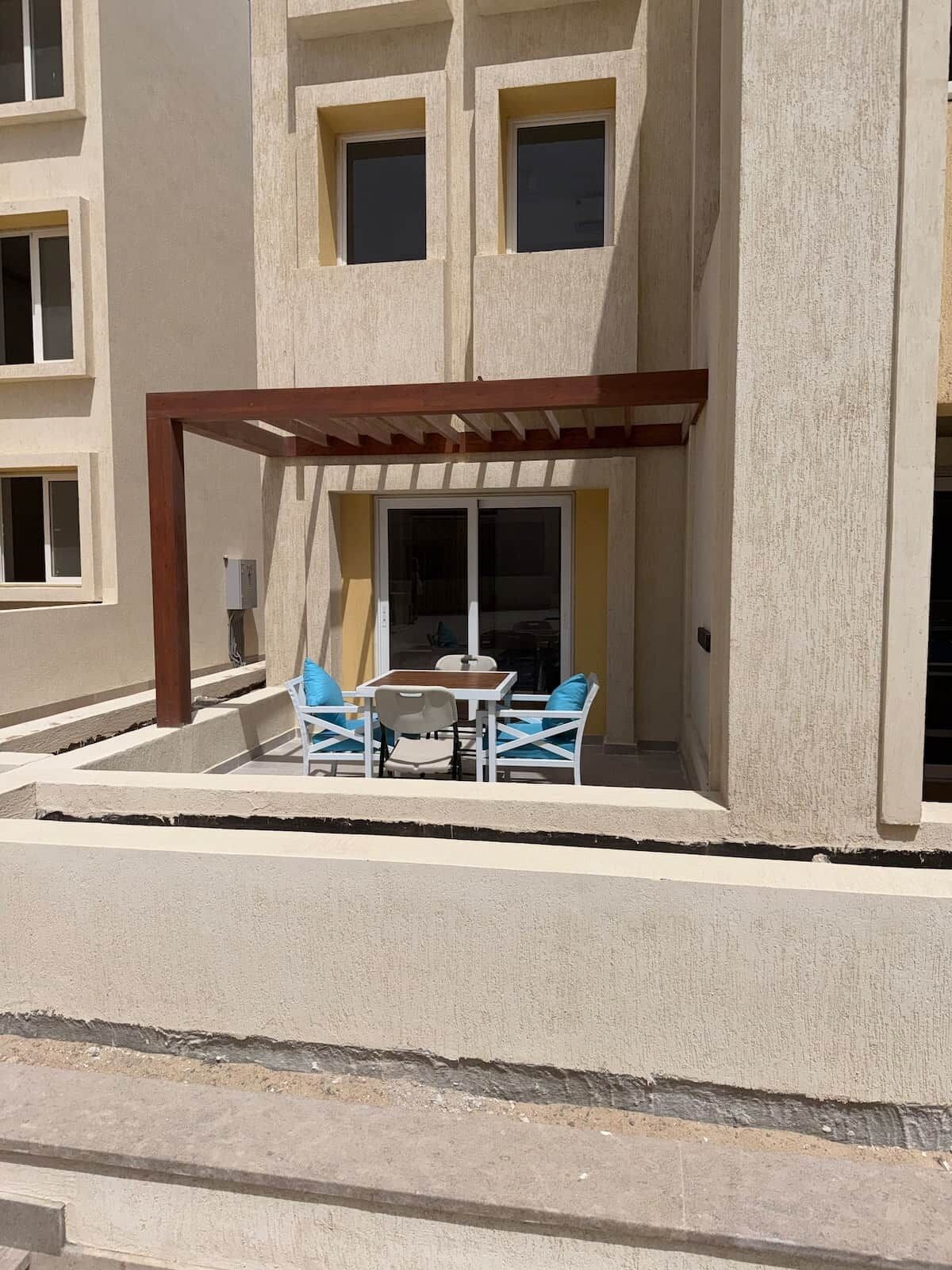 Een gebouw met een overdekt terras, een raam en een deur.