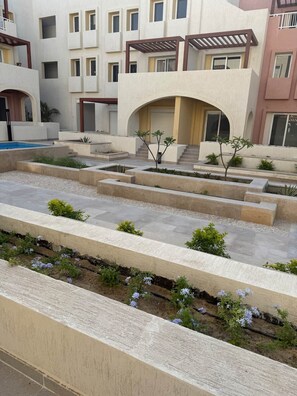 Edifici modern amb nombroses galeries, un pati central amb plantes i una piscina.