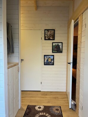 A hallway with wooden walls, a door, and a rug with a floral pattern.
