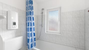 Ein modernes Badezimmer mit einer Badewanne, einer Dusche und einer Toilette. Es gibt ein Milchglasfenster und einen weißen, wandmontierten Seifenspender.