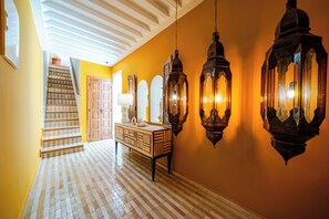 A hallway with a checkered floor, a staircase, a wooden cabinet with a mirror, and two hanging lanterns. - Riad Le Bertal - Private Beldi Chic Riad with Pool & Sunset Rooftop in Medina (Marrakech)