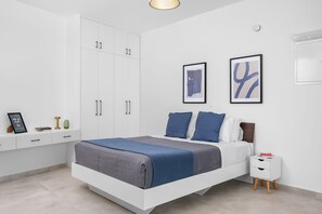 Een moderne slaapkamer met een bed, nachtkastjes en kunst aan de muur.