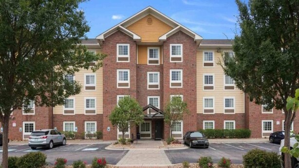 A multi-story hotel with a brick facade, a central entrance, and a parking lot. - 2 Queen Beds|Non-Smoking, Kitchen (Lenexa)