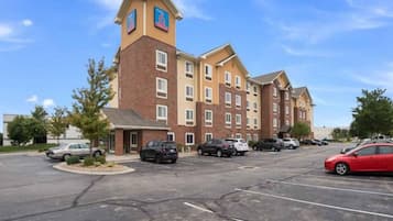 A multi-story hotel with a parking lot in front.