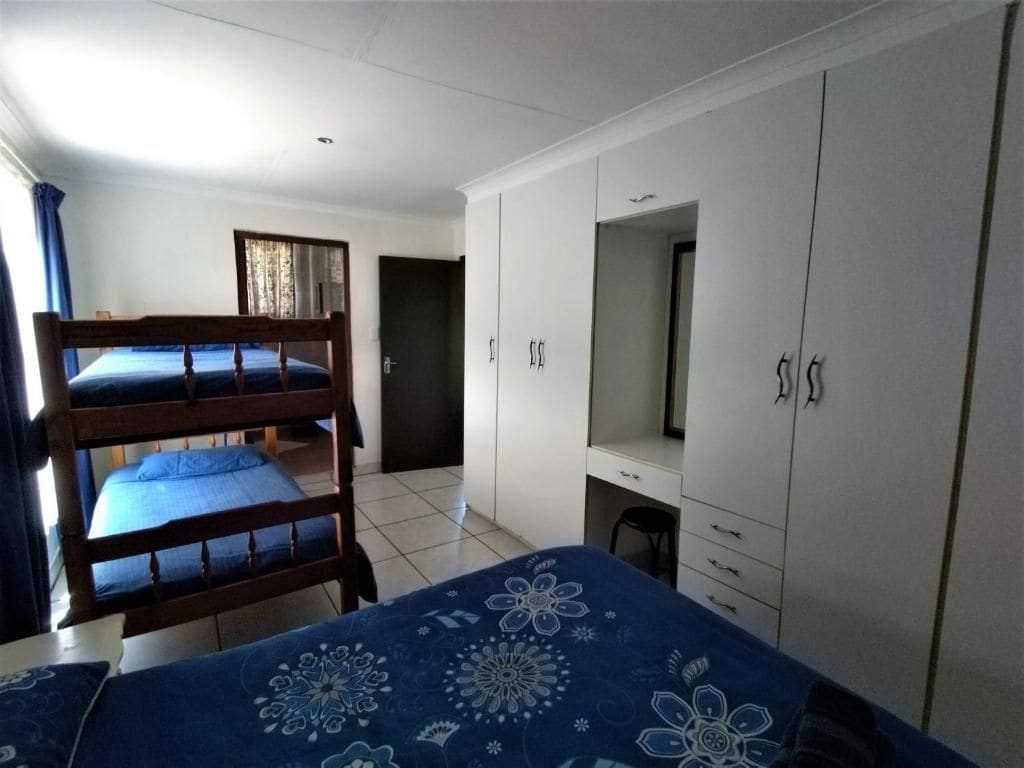 A room with bunk beds, a desk, and a wardrobe.