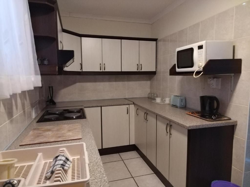 Eine kompakte Küche mit Mikrowelle, Toaster und Kaffeemaschine.