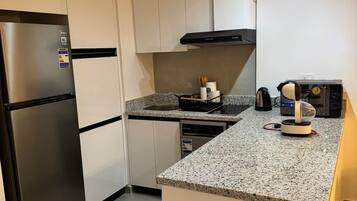 Una cocina moderna con refrigerador integrado, estufa y microondas.