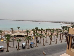 A beachside view with palm trees, a covered seating area, and a view of the sea. - G04 one bedroom apart/balcony/fountain view (Hurghada)