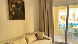 Uma sala de estar com sofá, mesa de centro e um quadro na parede.
