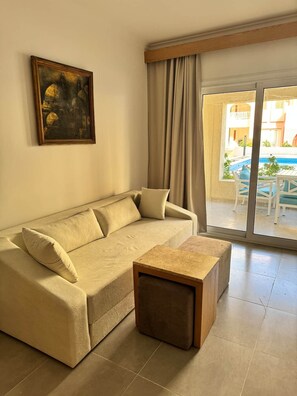 Ein Wohnzimmer mit einer Couch, einem Couchtisch und einem Gemälde an der Wand.