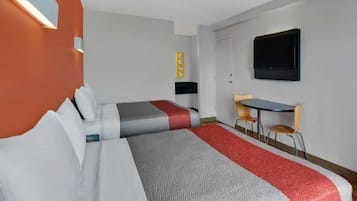 Una camera d'albergo con due letti, una scrivania, una sedia, un televisore e un piccolo tavolino.