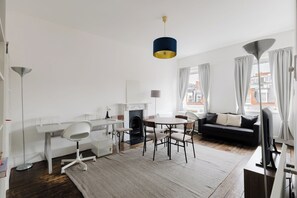 Ein modernes Wohnzimmer mit einem runden Esstisch, einer Couch und einem Kamin.