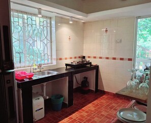 A compact kitchen with a gas stove, a sink, and a window with decorative bars. - Fun at the sea - enjoy Strawberry! (Calangute)