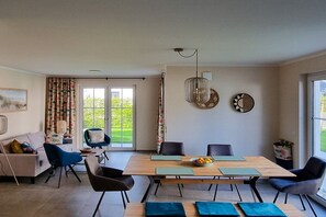A dining area with a wooden table, chairs, and a bowl of fruit. - Holiday home with 3 bedrooms (Breege\/ Juliusruh OT Breege)