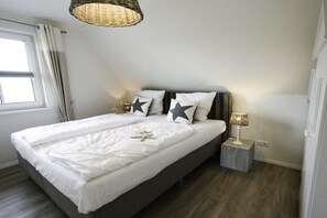 A bedroom with a bed, a bedside lamp, and a starfish decoration. - Holiday home with 2 bedrooms (Fuhlendorf)