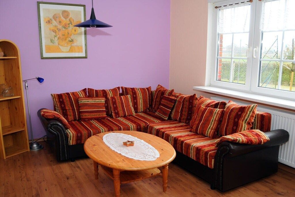 Une pièce comprenant un canapé, une table basse en bois, un lampadaire et une fenêtre donnant sur un beau paysage.
