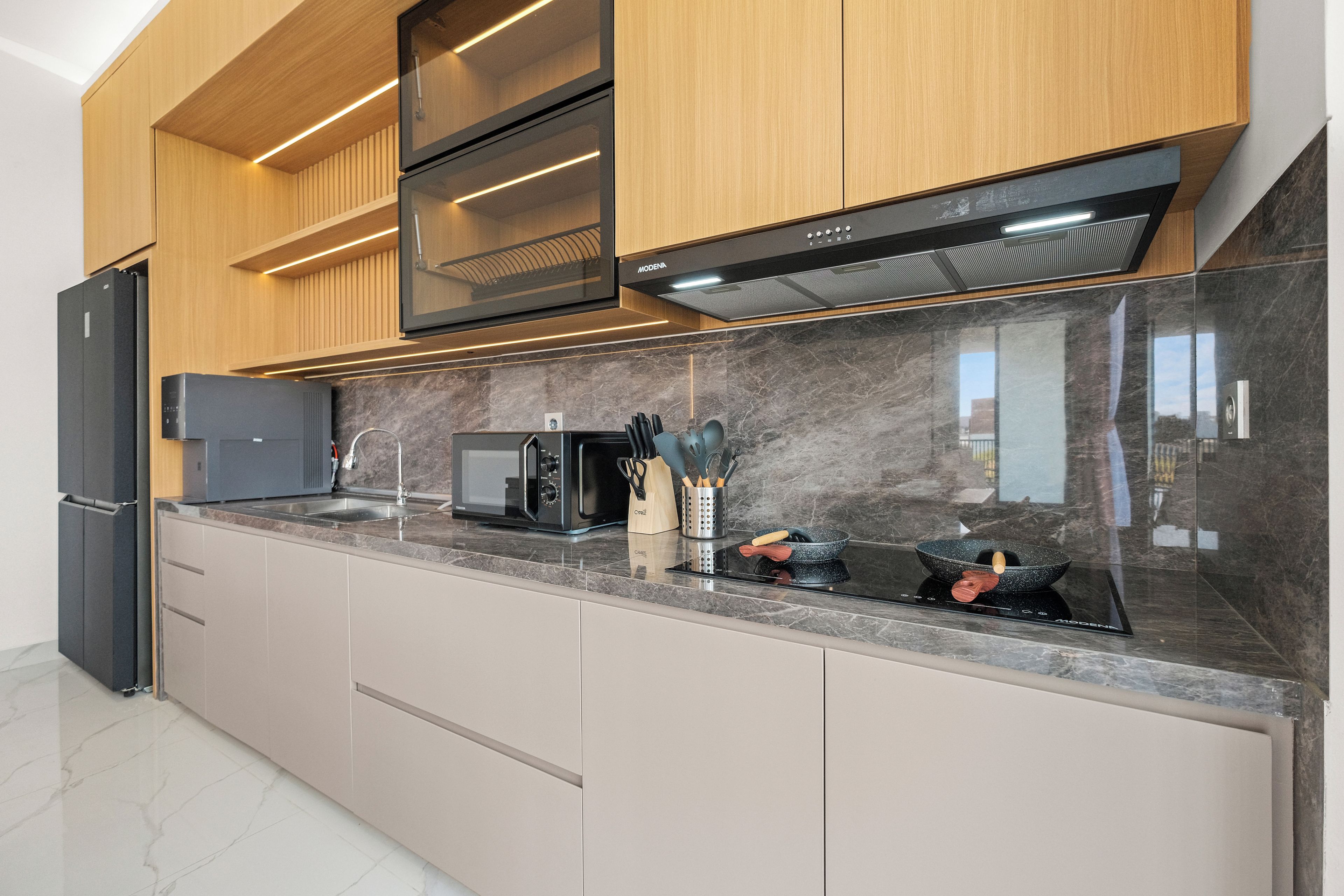 A modern kitchen with built-in appliances, a microwave, and a range hood.