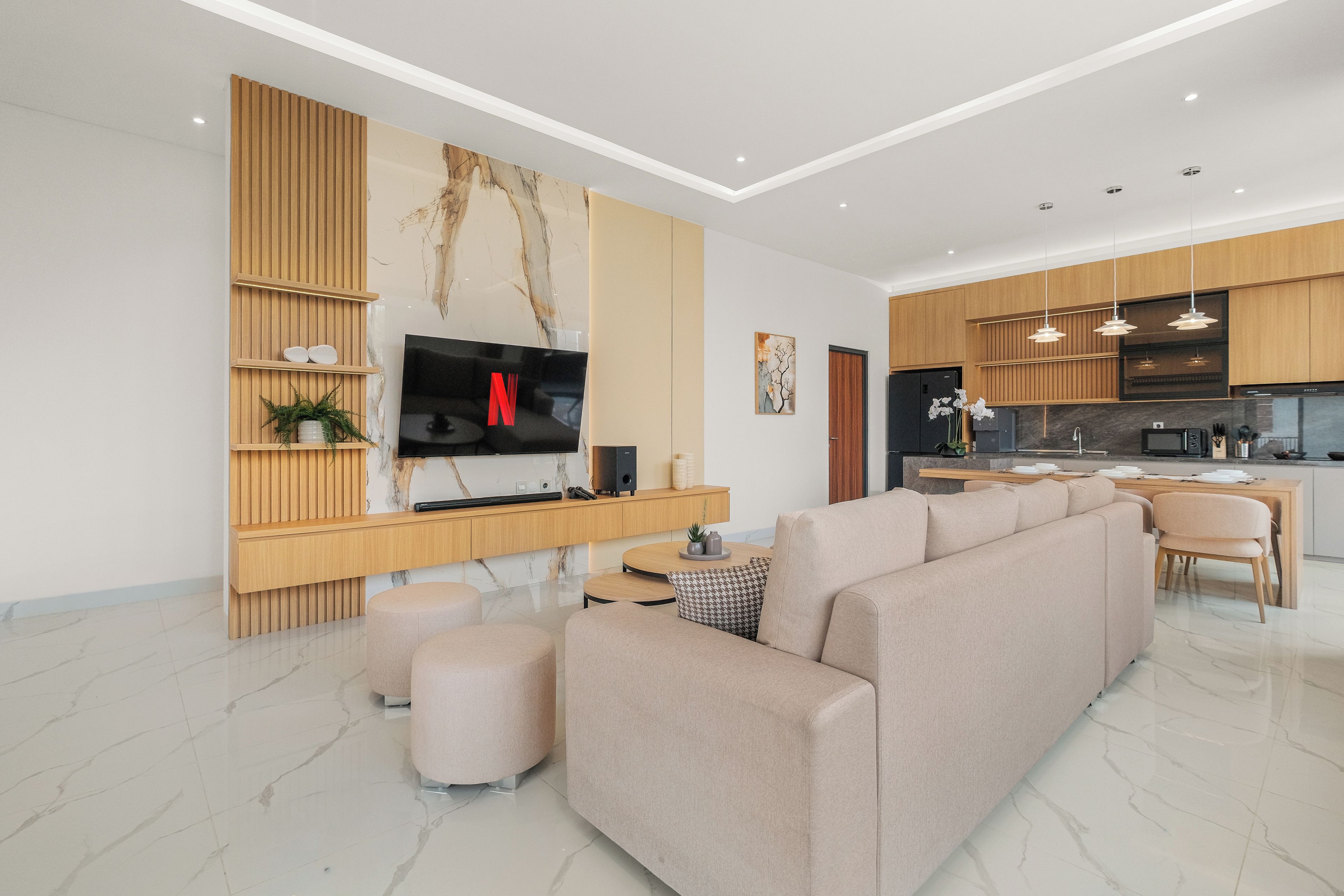 Ein modernes Wohnzimmer mit einem modularen Sofa, einem Flachbildfernseher und einer Holzunterhaltungseinheit.