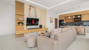 Ein modernes Wohnzimmer mit einem modularen Sofa, einem Flachbildfernseher und einer Holzunterhaltungseinheit.
