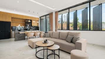 A modern living space with a sofa, coffee table, and dining area.