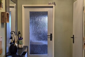 A door with a textured glass panel, a black door handle, and a small shelf above it. - Mountain View Apartment near Winterberg (Winterberg)
