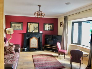 A living room with a fireplace, a television, a sofa, and a chair.