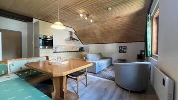 A modern interior with a dining area, kitchen, and seating space.