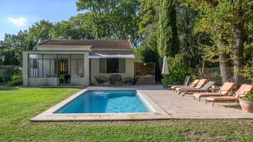 Uma casa moderna com piscina, área de estar externa e jardim.