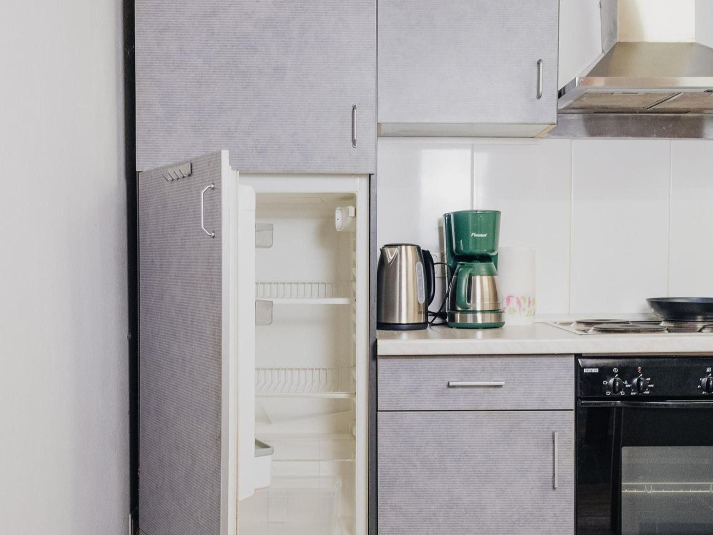 A kitchen with a built-in refrigerator, a coffee maker, and a stove.
