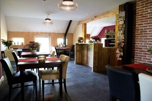 Ein Essbereich mit Holztisch und Stühlen, einer Kristallleuchter und einer Ziegelwand mit einer Ablage für Gegenstände.
