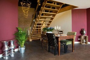 Ein Essbereich mit einer Holztreppe, einem Tisch mit Stühlen und dekorativen Vasen.