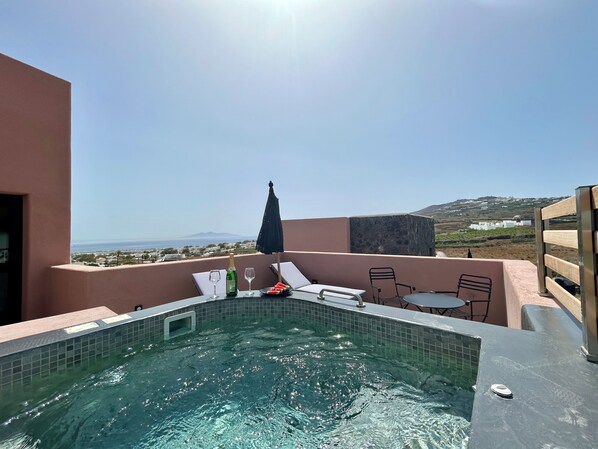 A rooftop pool with a clear view of the sea and distant hills.