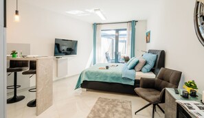 A modern bedroom with a bed, a TV, a desk, and a chair. - Romantic Wellness 2 – Prague Žižkov (Praha 3 - Žižkov)
