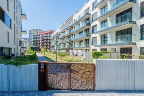 A modern apartment complex with multiple balconies, a gated entrance, and a pathway leading to the buildings. - Romantic Wellness 2 – Prague Žižkov (Praha 3 - Žižkov)