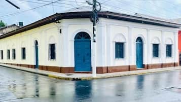 A building with a flat roof, multiple windows, and a central door.