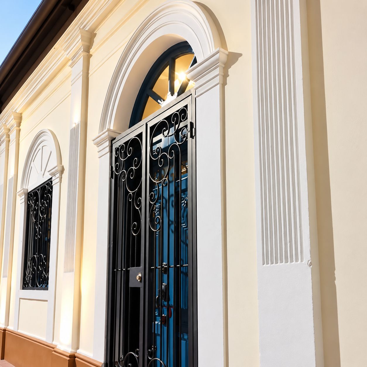 A building facade with arched windows and a black metal gate.