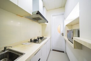 A compact kitchen with a gas stove, a microwave, and a sink.