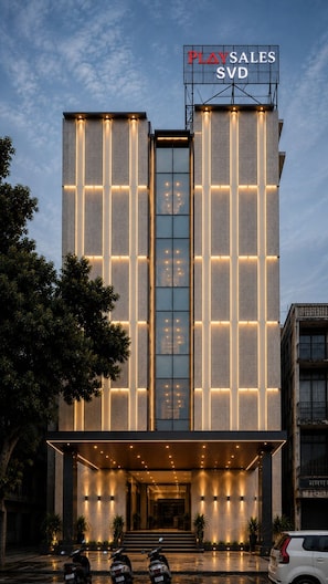 Un edificio moderno con un letrero llamativo que dice 'PLAYS SALES SVD' en la parte superior.