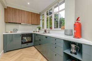 A modern kitchen with a built-in oven, a coffee maker, and a fire extinguisher. - Central Stylish 1 Bed | Near Stockbridge (Edinburgh)