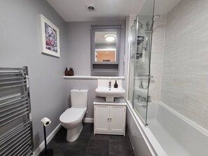 A bathroom with a toilet, sink, and shower. - Portobello Garden Flat | 2 bed Near Beach (Edinburgh)