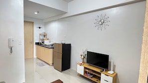 A modern kitchen with a microwave, refrigerator, and a flower vase on the counter. - 1-Bedroom Condo with wifi, near SM North (Quezon City)