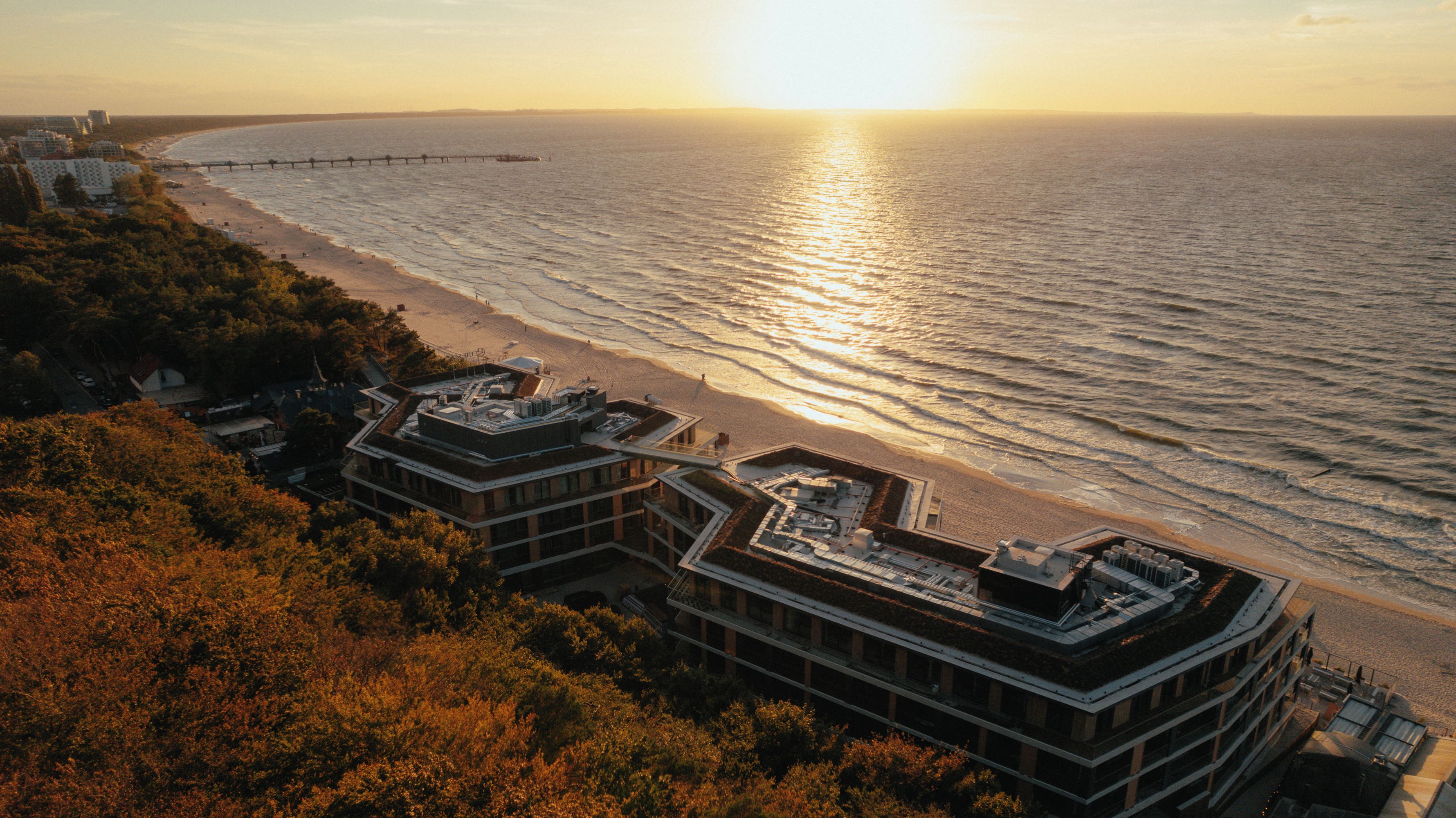 A coastal building with a rooftop terrace overlooking the beach and ocean.