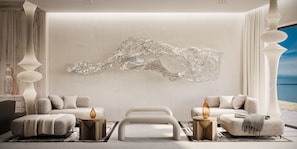 Ein modernes Wohnzimmer mit einer großen abstrakten Skulptur, zwei Sofas, einem Couchtisch und dekorativen Vasen.
