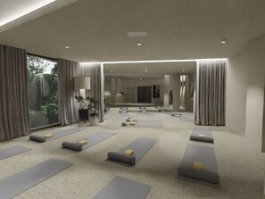 Ein Yoga-Studio mit in Reihen angeordneten Matten, großen Fenstern und einer neutralen Farbgestaltung.