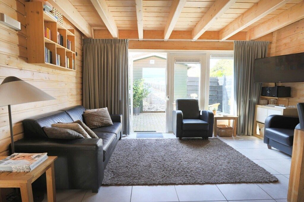 A cozy living room with a sofa, armchair, and a television.