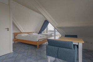 Une chambre à coucher avec un lit, une table et une chaise.